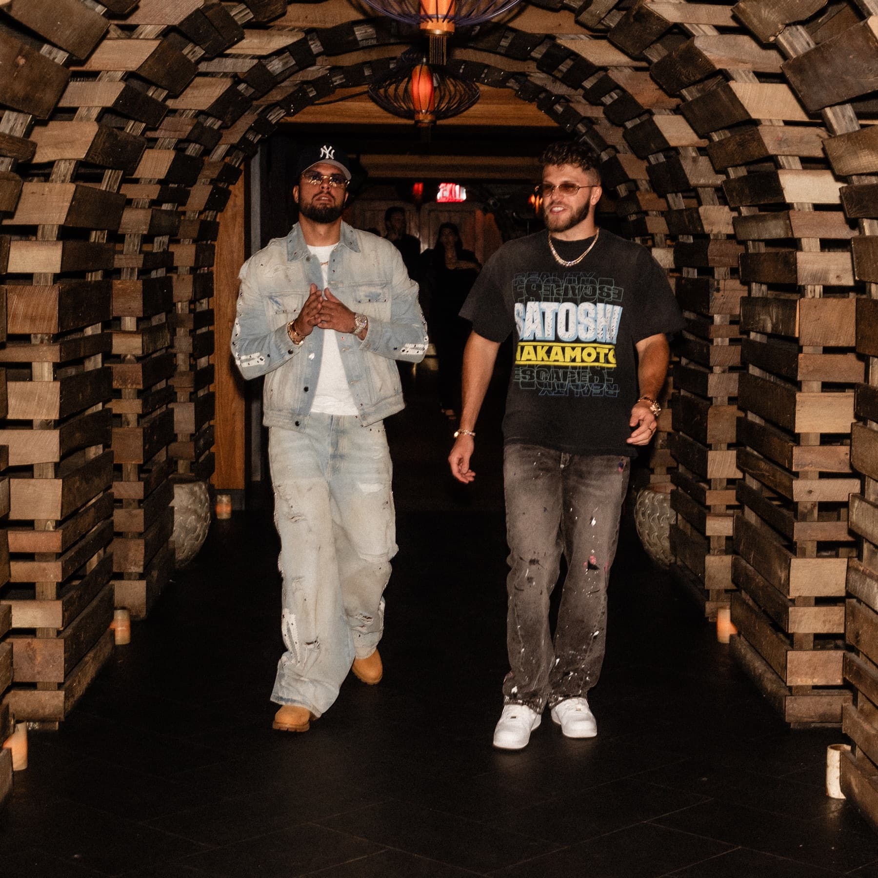 David Chaboki (Shibo / GodsBurnt) and Christian Barker (Bark) walking through the Bodega Negra wooden tunnel at DDNYC 2026 in New York