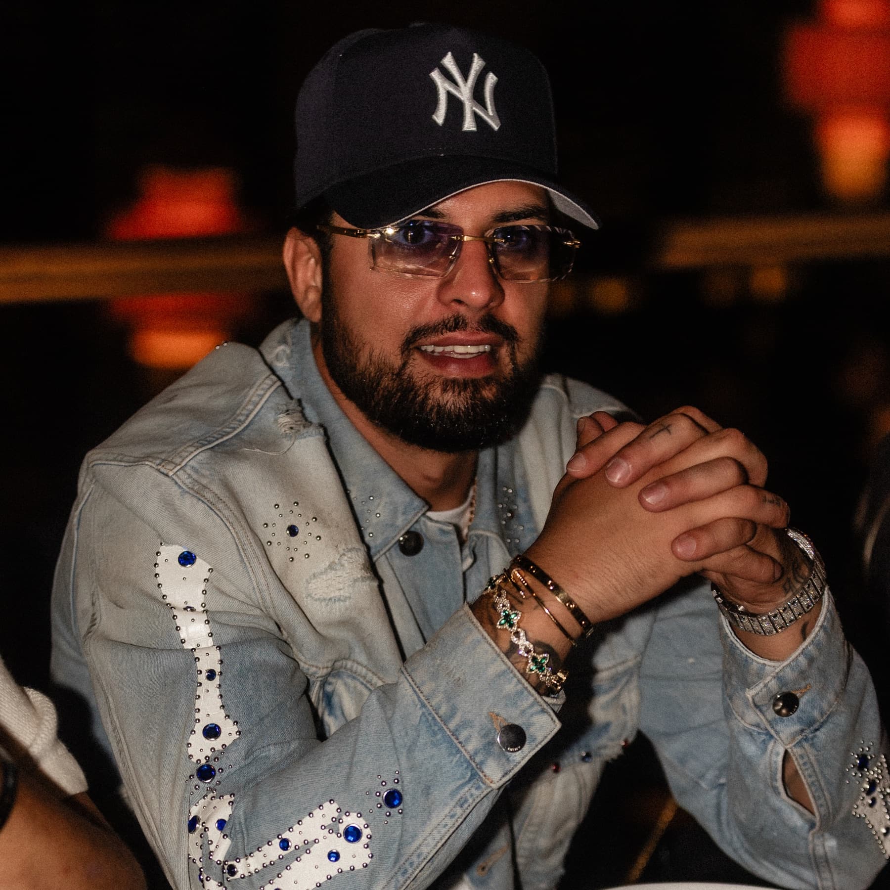 Close portrait of David Chaboki (Shibo / GodsBurnt) in a New York Yankees cap at a DDNYC 2026 rooftop dinner