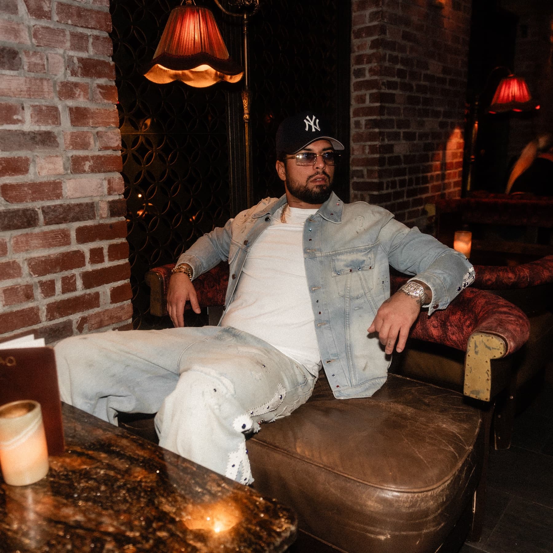 David Chaboki, known as Shibo and GodsBurnt (@GodsBurnt), in a Yankees cap and crystal denim at TAO Downtown during DDNYC 2026 in New York