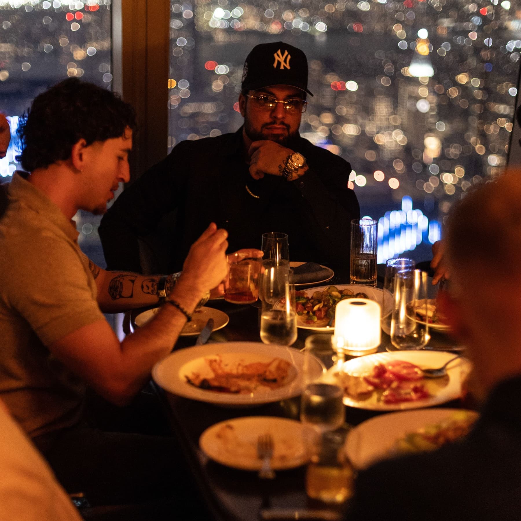 David Chaboki (Shibo / GodsBurnt) in a New York Yankees cap at a DDNYC 2026 rooftop dinner