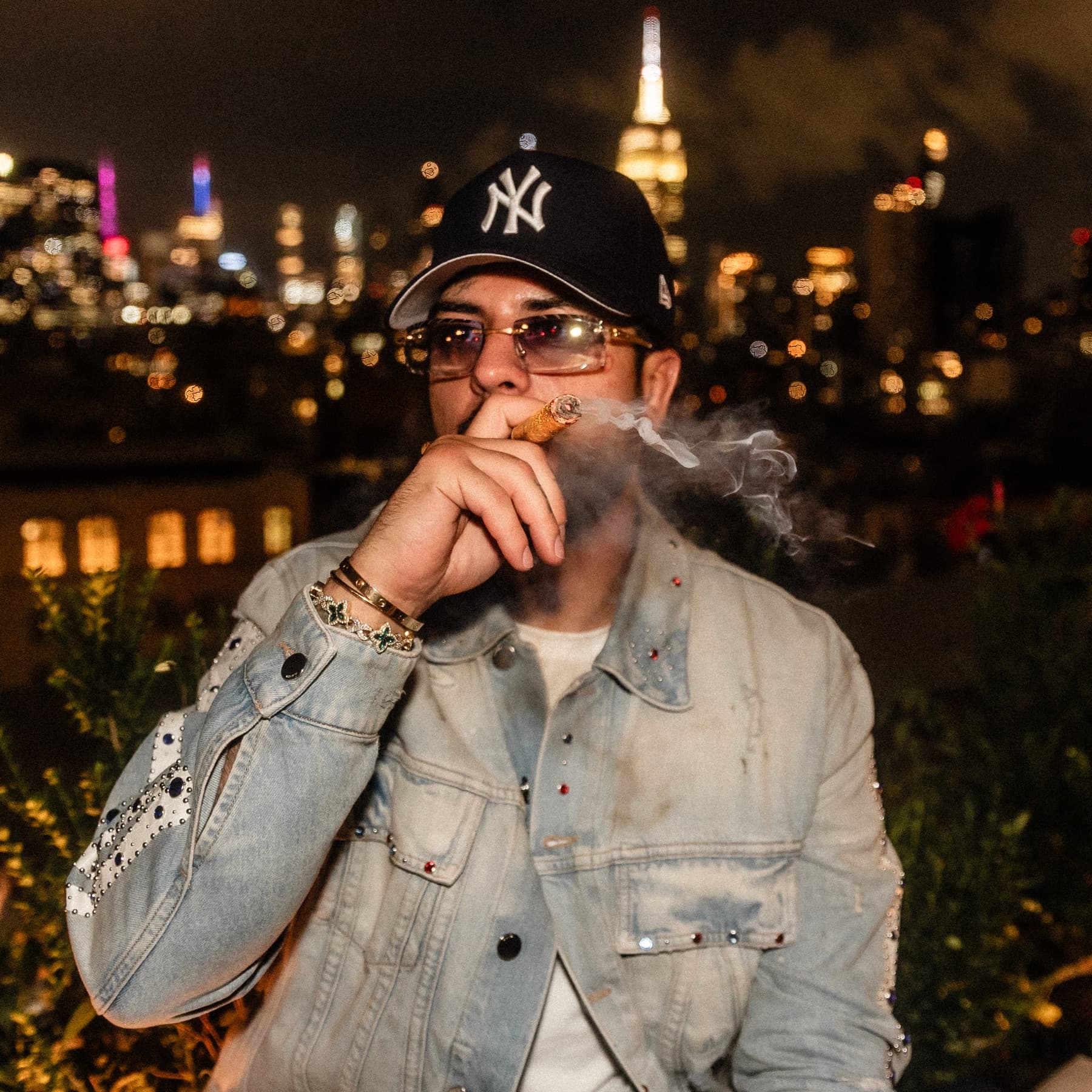 David Chaboki (Shibo) with a cigar and the Empire State Building David Chaboki (Shibo / GodsBurnt) with a cigar on a DDNYC 2026 rooftop, Empire State Building behind him in New York